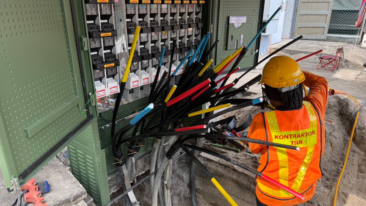 NIKKISO-AYSHA TNB contractor performing heat-shrink cable termination at an LV feeder pillar in Penang